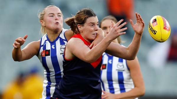 Vikki Wall, left, pictured in action for the Kangaroos last week against the Demons