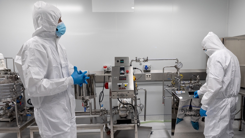 Technicians inspect lab machinery as part of the WHO's mRNA technology transfer hub in Cape Town, South Africa