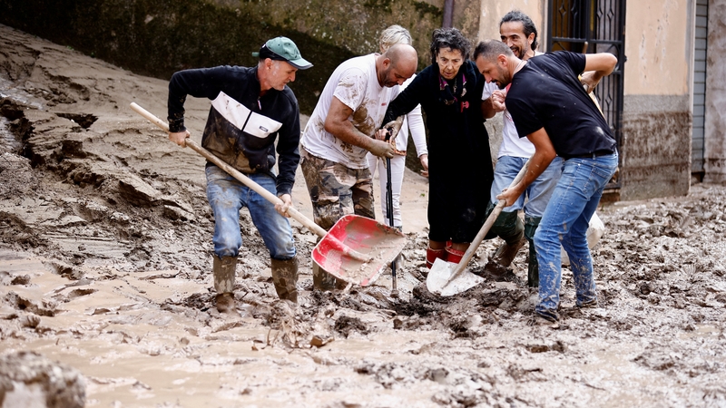 People help an elderly woman after heavy rains and floods hit the central Italian region of Marche, in Cantiano