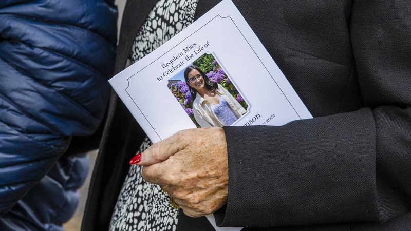 A mourner carries the order of service at the funeral of Hollie Thomson at St Michael's Church, west Belfast