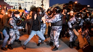 Police officers detain a man in Moscow today