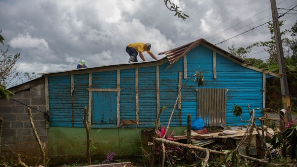 A man repairs the roof of a house in the northeast of the Dominican Republic after the hurricane