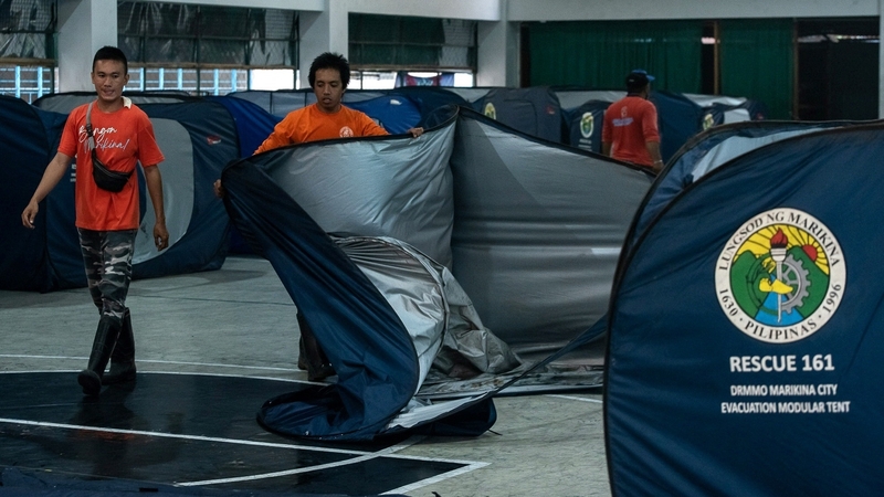 Officials set up tents in a makeshift evacuation centre at a basketball court in Marikina City in Manila