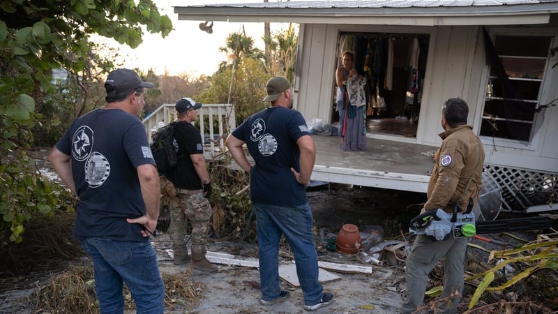 Members of the Project DYNAMO rescue organisation talk with a resident on Sanibel Island