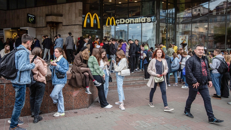 People seen waiting in line at a McDonald's restaurant in Kyiv - people are being urged to wear facemasks in certain settings