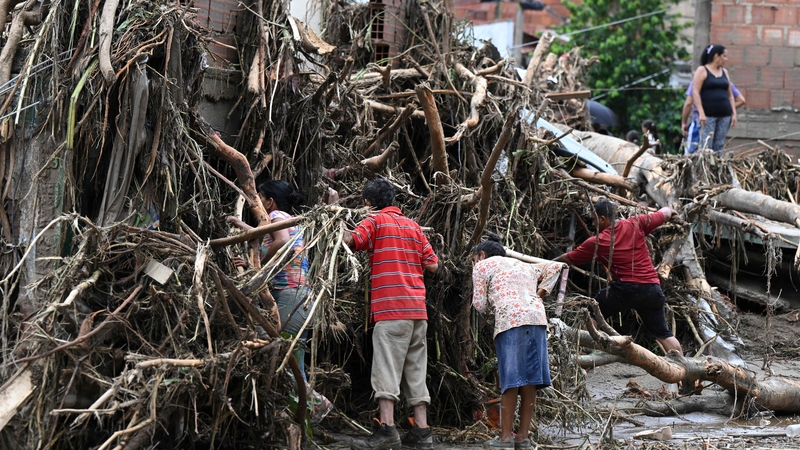 Residents search for missing relatives in the rubble of a house destroyed by a landslide during heavy rains in Las Tejerias, Aragua state, Venezuela