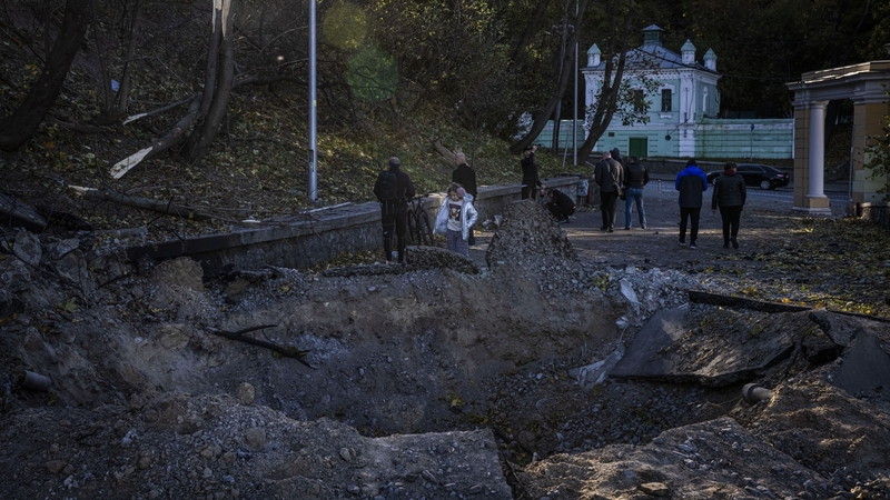 A little girl looks at the site of a blast by a pedestrian bridge overlooking the Dnipro River in Kyiv today