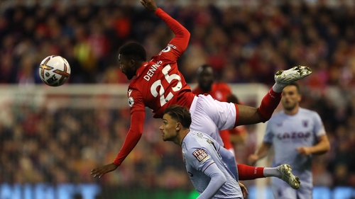 Nottingham Forest striker Emmanuel Dennis jumps above Aston Villa defender Matty Cash