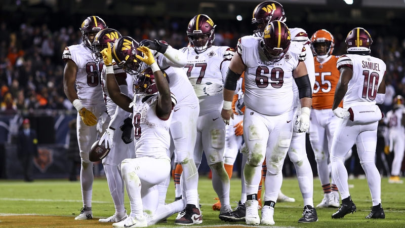 Brian Robinson (8) celebrates with Washington team-mates after scoring the game-winning touchdown