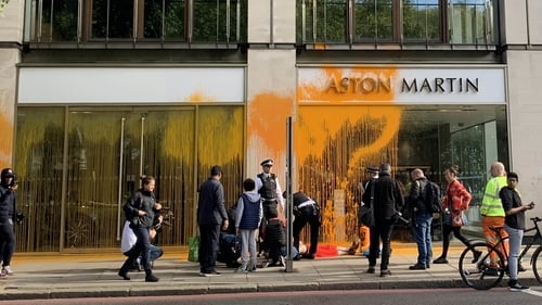 Police with Just Stop Oil protesters who have blocked Park Lane in central London and sprayed paint over an Aston Martin car showroom