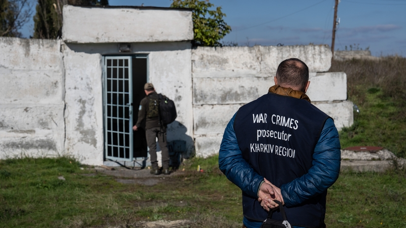 A war crimes prosecutor looks on during a search for evidence in Kharkiv, Ukraine, last week