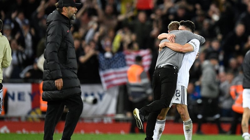 Leeds striker Patrick Bamford (R) and manager Jesse Marsch hug at the final whistle after beating Jurgen Klopp's Liverpool