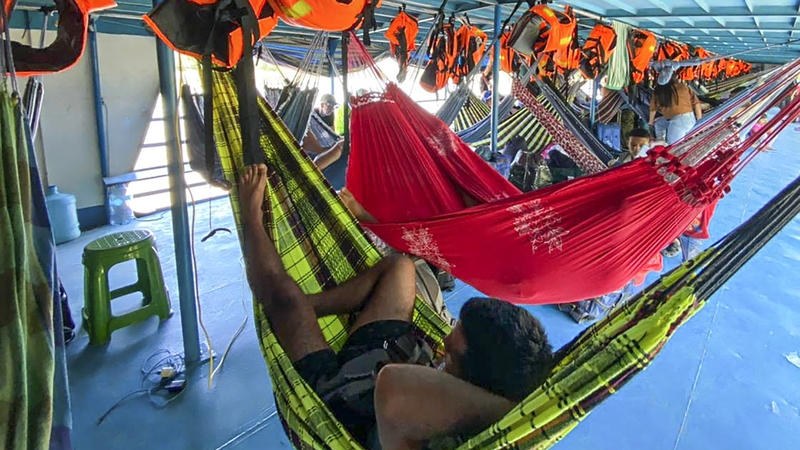Tourists rest in the boat where they have been detained at the Cuninico community