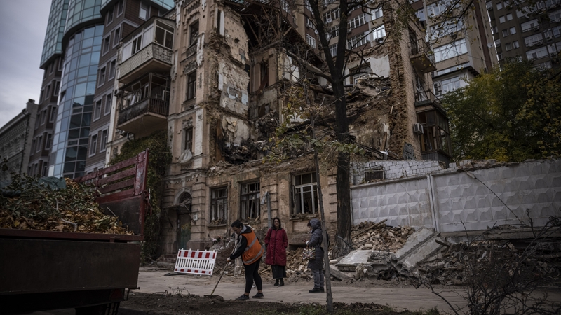 People clear debris outside a building in Kyiv where a couple was killed in a Russian drone in October