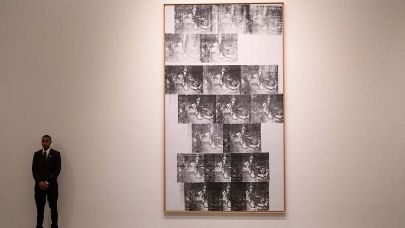 A security guard stands next to Andy Warhol's 'White Disaster [White Car Crash 19 Times]' during a press preview for Sotheby's auctions of Modern & Contemporary art