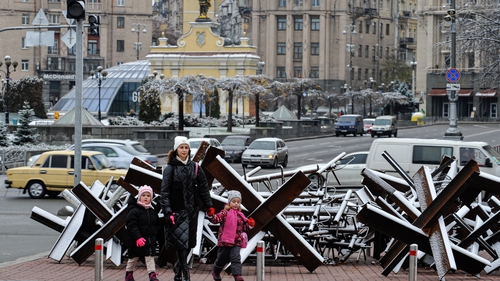 A woman and children walk through Kyiv's Independence Square