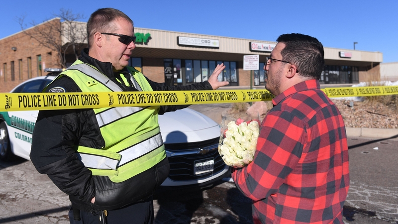 A member of the public brings flowers to the scene in Colorado