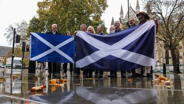 Supporters for Scottish independence hold national flags outside the Supreme Court in London