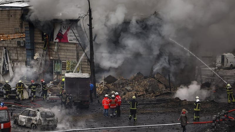 Fire and rescue workers attend a building hit by a Russian missile in central Kyiv