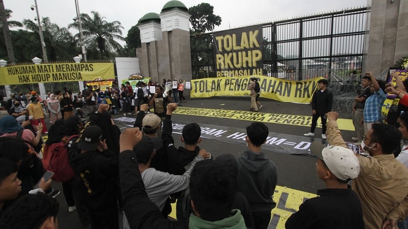 Activists hold a protest against the new criminal code outside the parliament building in Jakarta
