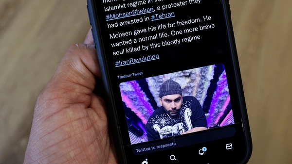 A mobile phone displaying a Tweet about the hanging by Iranian authorities of Mohsen Shekari