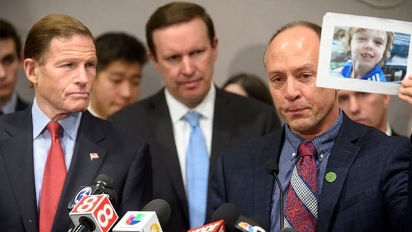 Connecticut Senators Richard Blumenthal and Chris Murphy stand with Mark Barden of Newtown, as he holds a photograph of his son Daniel