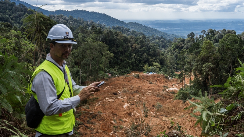 Malaysia authorities inspect the aftermath of a landslide that hit a campsite in the state of Selangor, Malaysia