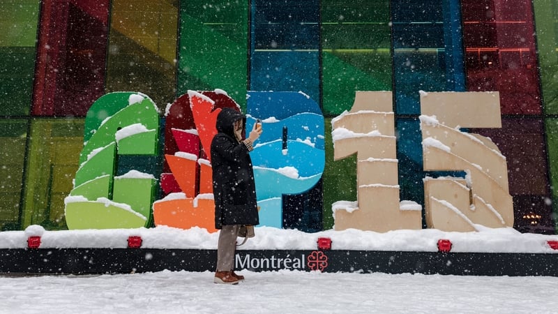 A person takes a picture by the COP15 logo in front of the Palais des Congres at the United Nations Biodiversity Conference (COP15) in Montreal, Canada