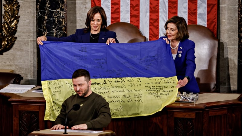 US House Speaker Nancy Pelosi and US Vice President Kamala Harris hold a Ukrainian flag signed by soldiers in war-torn Bakhmut
