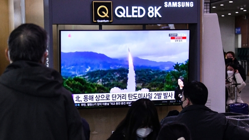 People watch a news report with file footage of a North Korean missile test, at a railway station in Seoul this morning
