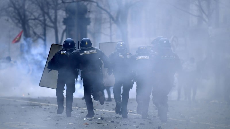 French riot police run amid tear gas smoke during clashes following a demonstration