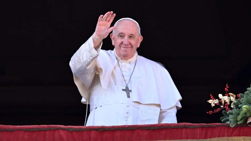 Pope Francis waves to the crowd as he appears at the balcony to deliver his Christmas Urbi et Orbi blessing