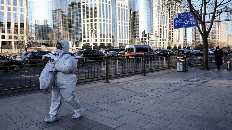 A woman wearing personal protective equipment walking in Beijing yesterday
