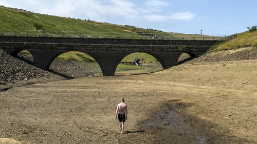 A file photo from July of a person walking a dry bank of a tributary to the Dowry Reservoir close to Oldham
