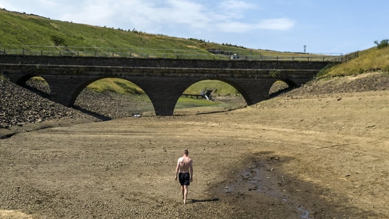 A file photo from July of a person walking a dry bank of a tributary to the Dowry Reservoir close to Oldham