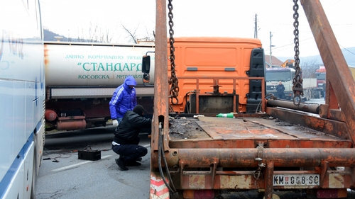Kosovo Serbs remove trucks from a road barricade set up by ethnic Serbs in the village of Rudare