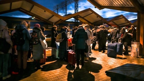 Ukrainians standing in line at passport control after arriving on the evening train from Ukraine to Przemysl in Poland