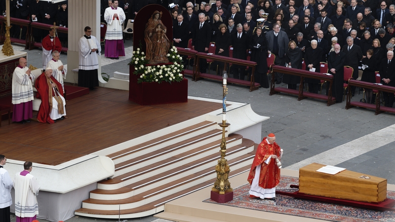 Pope Francis sits in a wheelchair as the coffin of late Pope Emeritus Benedict XVI is carrying after a funeral mass at St. Peter's Square at the Vatican on 5 January