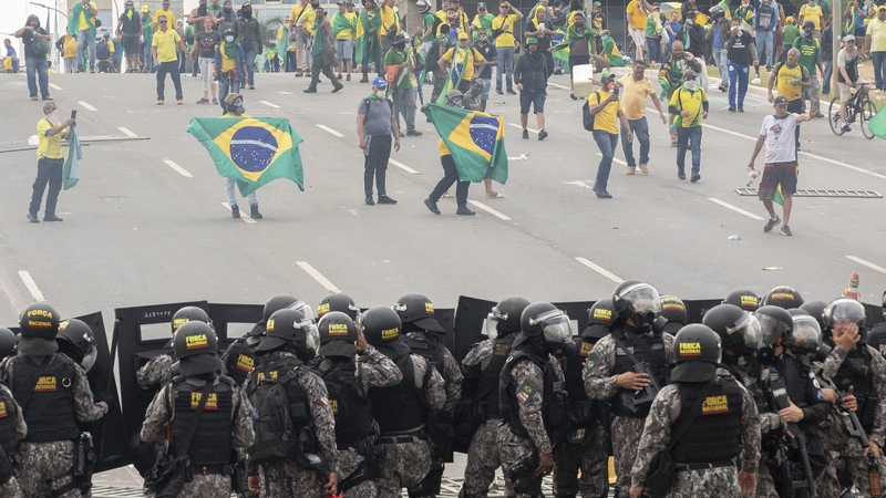 Bolsonaristas agus póilíní ag tabhairt aghaidh ar a chéile in Brasília