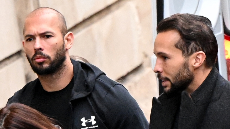 Andrew Tate (C)and his brother Tristan Tate (R) arrive at a courthouse in Bucharest earlier this month