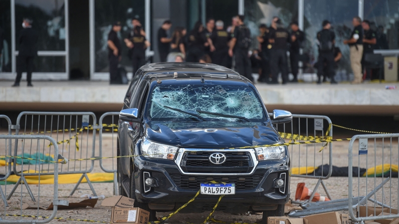 A vandalized vehicle remains outside the Supreme Court building in Brasilia