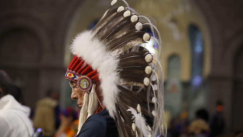 An Indigenous man bows his head as Pope Francis says mass in Canada last year