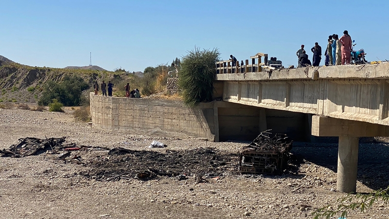 Residents view the wreckage of a burnt passenger bus in Lasbela district of Pakistan's Balochistan province