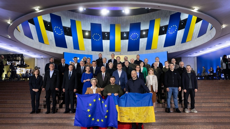 Ukrainian President Volodymyr Zelensky, centre, and European Commission President Ursula von der Leyen pose for a photo with Ukrainian and European Union flags