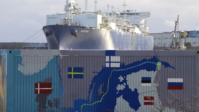 Floating Storage and Regasification Unit (FSRU) "Neptune" is pictured behind a container painted with a map showing the Nord Stream 2 gas pipeline Photo: Getty Images