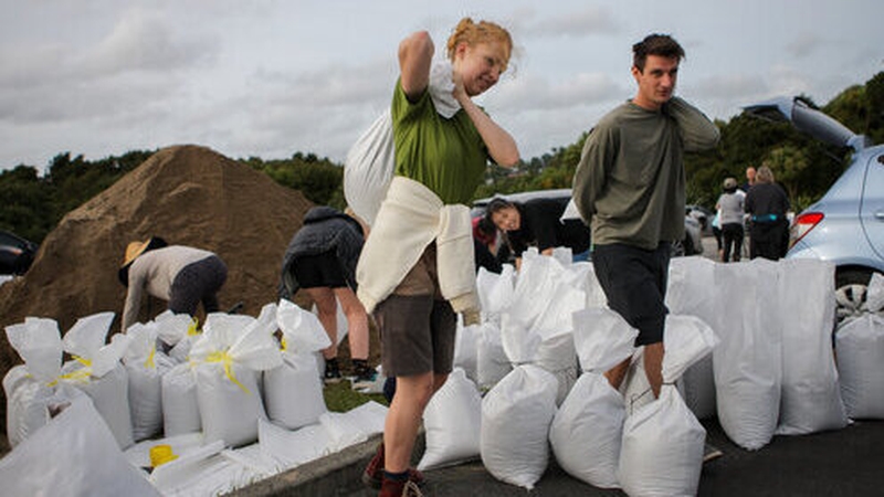 Auckland residents carry sandbags as they prepare for severe weather