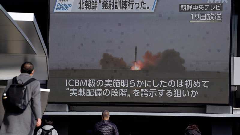 Pedestrians walk past a screen in Tokyo displaying North Korea's missile launch in footage broadcasted by Korean Central Television