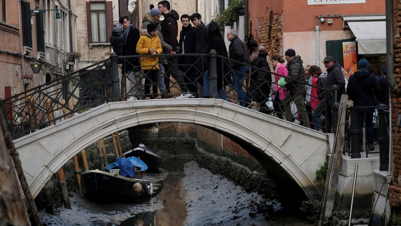 Boats are pictured in a canal during a severe low tide in Venice