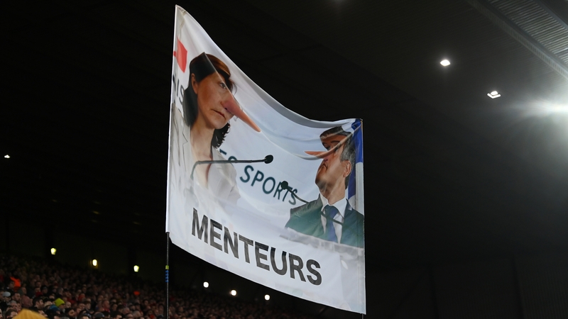 A banner in the Kop, depicted Gerald Darmanin, Minister of the Interior of France, and Amelie Oudea-Castera, Minister for Sport and the Olympic and Paralympic Games of France, with the wording "Menteurs" below