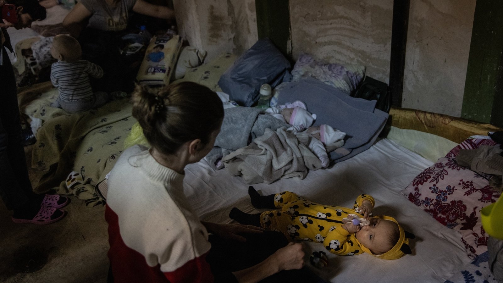 As air raid sirens sound over Kyiv, a mother tends to her baby in the bomb shelter of the paediatric ward of Okhmatdyt Children's Hospital on 29 February 2022.
